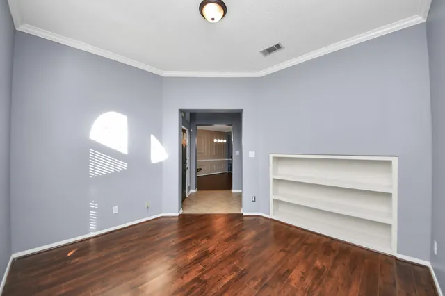 a view of a room with wooden floor and window