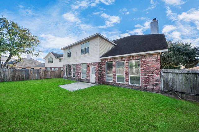an aerial view of a house with a garden and large trees