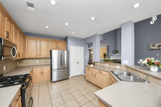 a kitchen with stainless steel appliances a refrigerator sink and cabinets