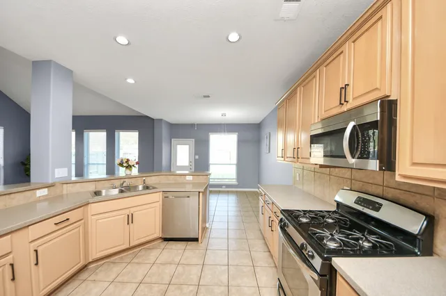 a kitchen with a sink stove and cabinets