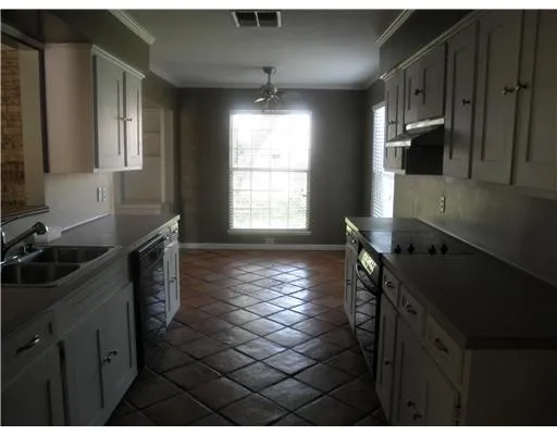 a kitchen with sink cabinets and window