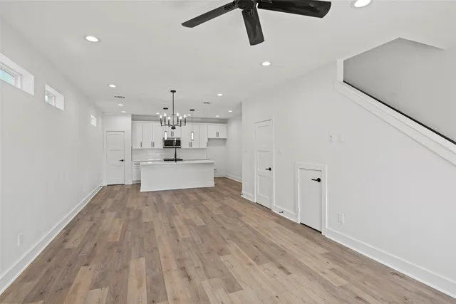 a view of kitchen with stainless steel appliances wooden floor and window