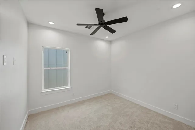 an empty room with chandelier fan