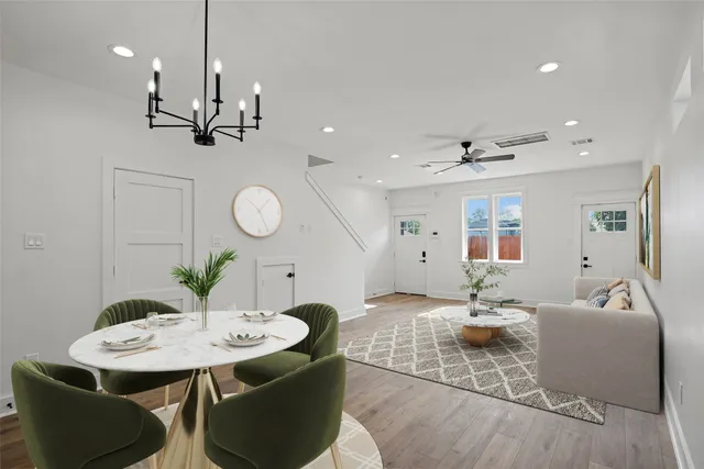 an empty room with wooden floor a ceiling fan and windows