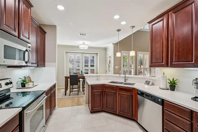 a kitchen with stainless steel appliances a sink stove and refrigerator