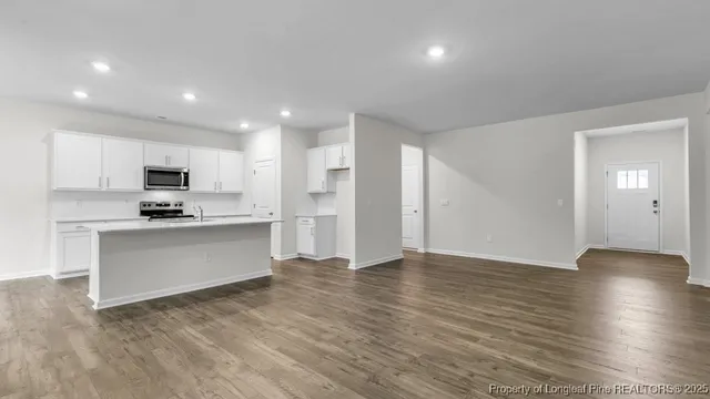 a view of kitchen with granite countertop stainless steel appliances refrigerator sink and cabinets