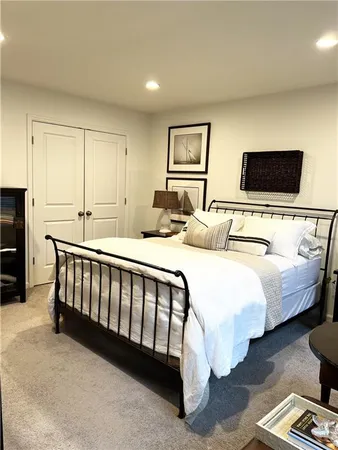 a bedroom with bed table and flat screen tv