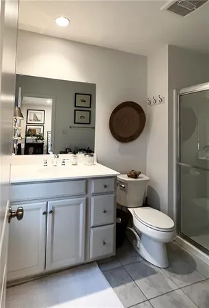 a bathroom with a granite countertop toilet sink and mirror
