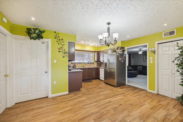 a kitchen that has a refrigerator and a wooden floor