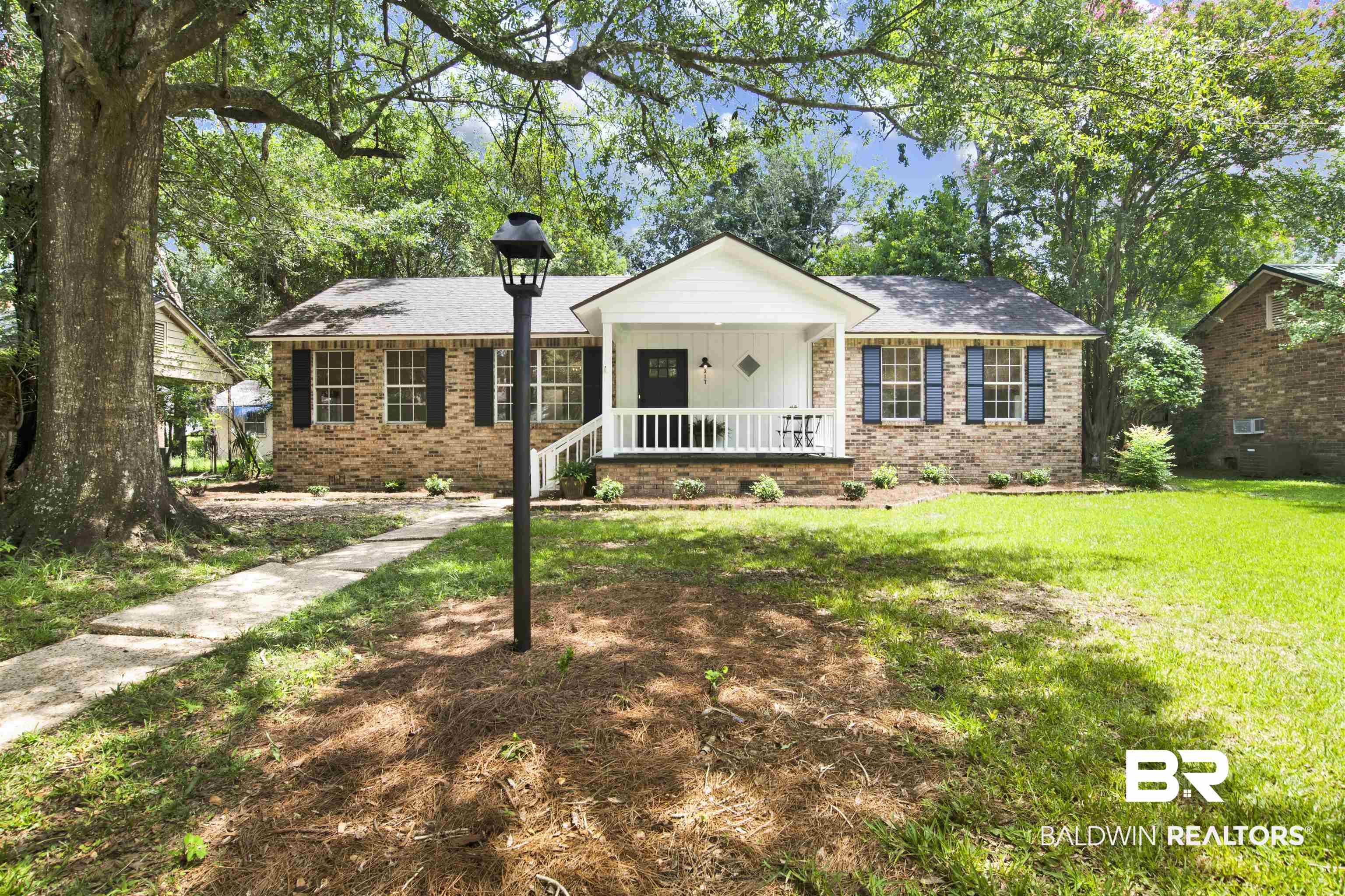 317 Lee Street Chickasaw, AL 36611 - Photo 1 of 40 Ranch-style house with a porch, brick siding, a front yard, and board and batten siding