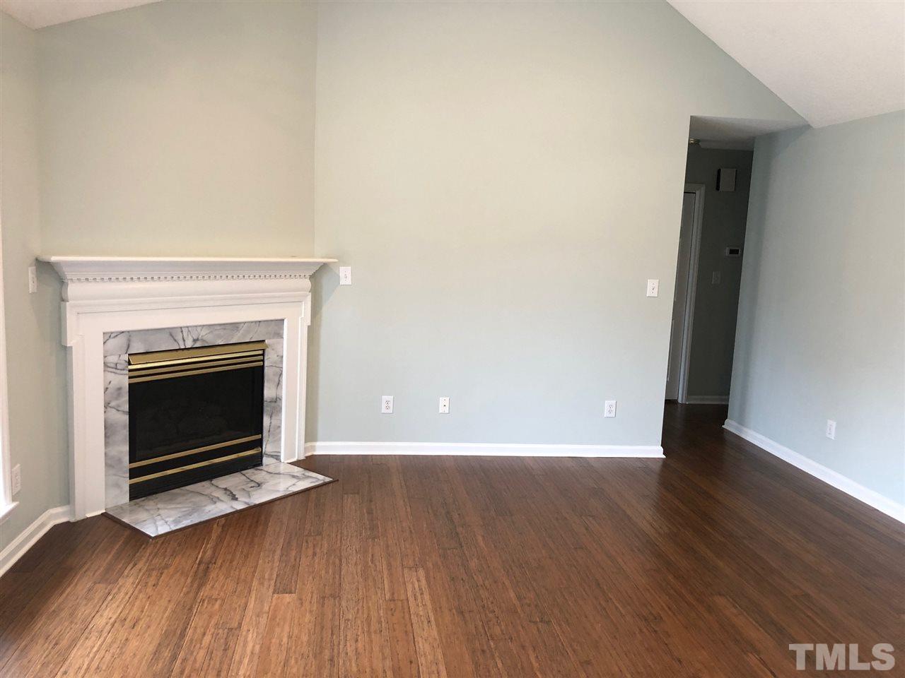 2108 Ruddy Road Raleigh, NC 27616 - Photo 3 of 19 a view of an empty room with wooden floor fireplace and a window