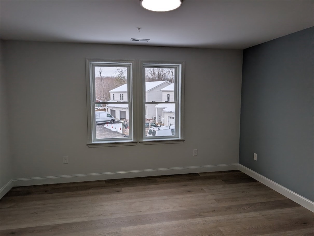778 Main Street, Unit 6 Leicester, MA 01524 - Photo 22 of 39 an empty room with wooden floor and windows