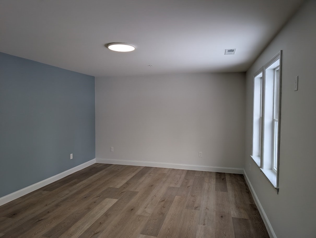 778 Main Street, Unit 6 Leicester, MA 01524 - Photo 27 of 39 an empty room with wooden floor and windows