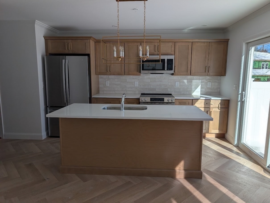 778 Main Street, Unit 6 Leicester, MA 01524 - Photo 9 of 39 a kitchen with kitchen island granite countertop a sink cabinets and stainless steel appliances