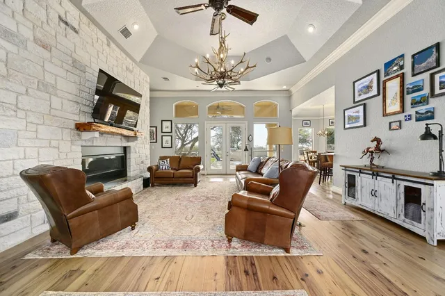 a dining room with furniture a chandelier and wooden floor