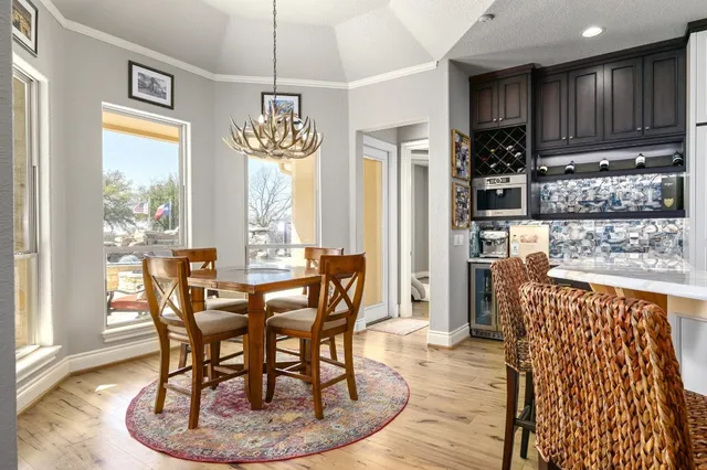 a kitchen with stainless steel appliances kitchen island granite countertop a stove a sink a dining table and chairs
