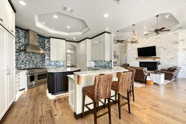 a kitchen with stainless steel appliances granite countertop a table chairs sink and cabinets
