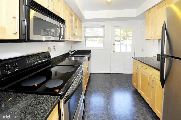 8508 Bradford Road, Unit 75 Silver Spring, MD 20901 - Photo 4 of 13 a kitchen with a stove a sink and a microwave