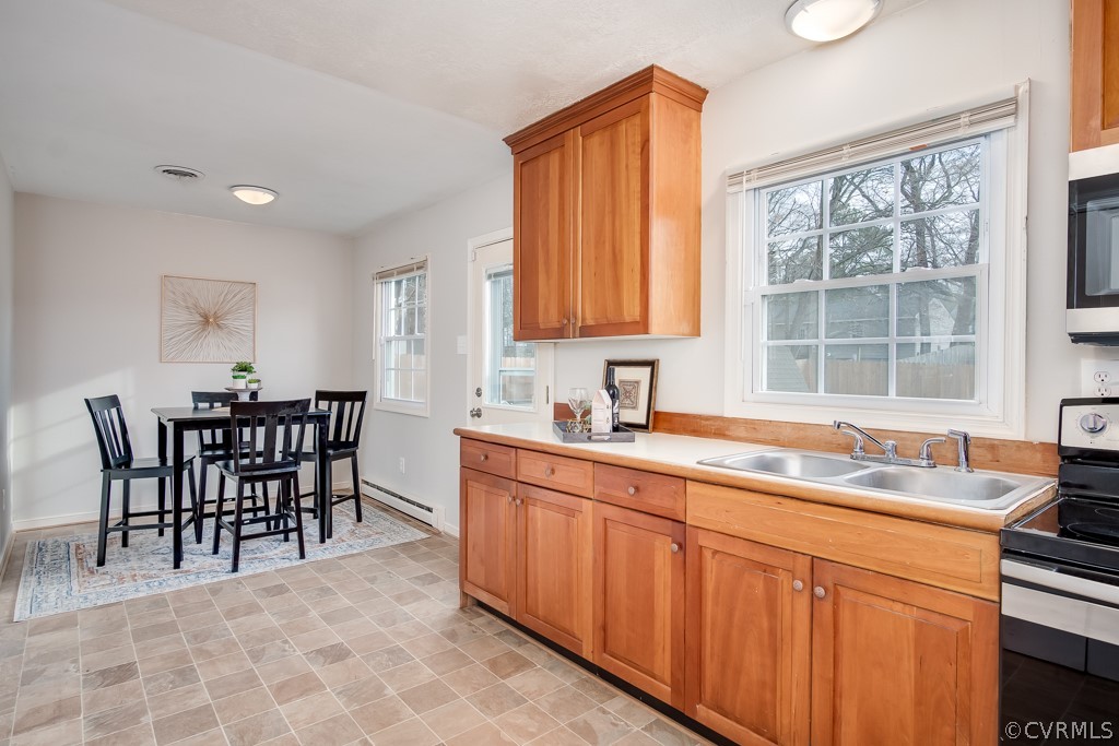 4705 Twelveoaks Road Midlothian, VA 23112 - Photo 10 of 25 a dining hall with stainless steel appliances granite countertop a sink a stove a dining table and chairs