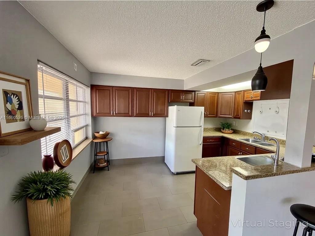 1821 Northeast 56th Street, Unit 4 Fort Lauderdale, FL 33308 - Photo 3 of 9 a kitchen with refrigerator and white cabinets