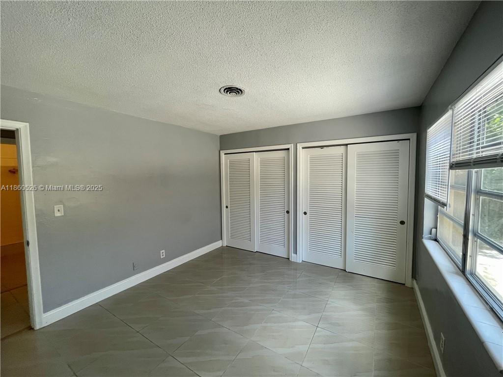 1821 Northeast 56th Street, Unit 4 Fort Lauderdale, FL 33308 - Photo 6 of 9 an empty room with large windows and entrance