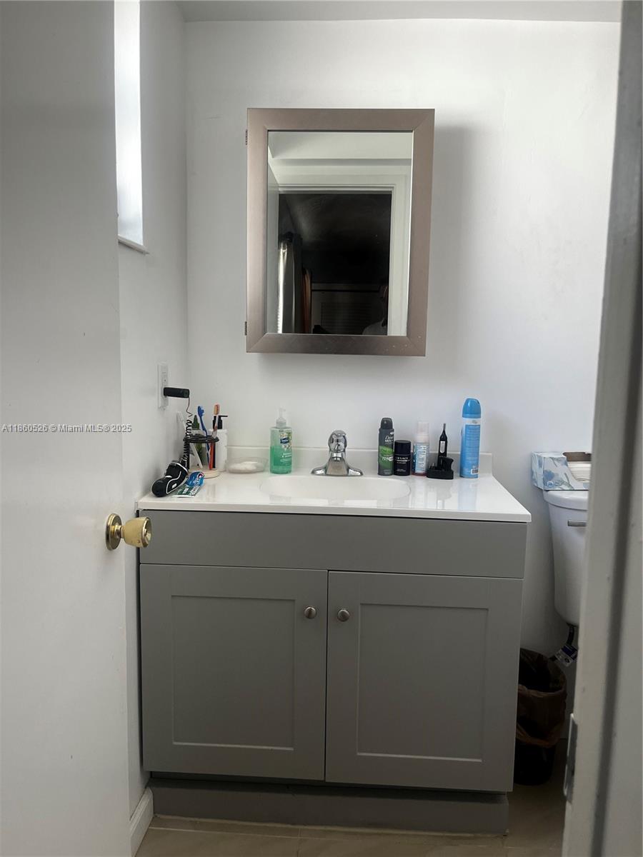 1821 Northeast 56th Street, Unit 4 Fort Lauderdale, FL 33308 - Photo 7 of 9 a bathroom with a sink and a mirror