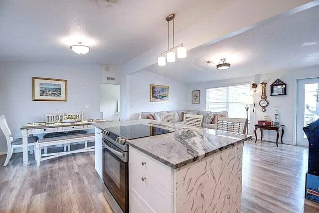 a view of a kitchen counter space a sink wooden floor and living room view