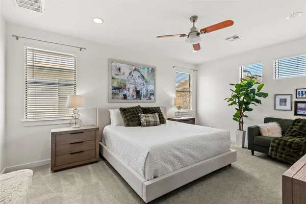 a bedroom with a bed a couch and a potted plant