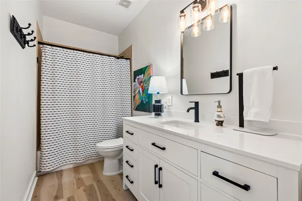 a bathroom with a sink a toilet and mirror