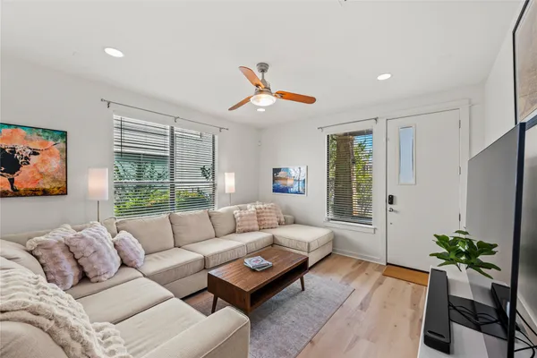 a living room with furniture potted plant and a large window