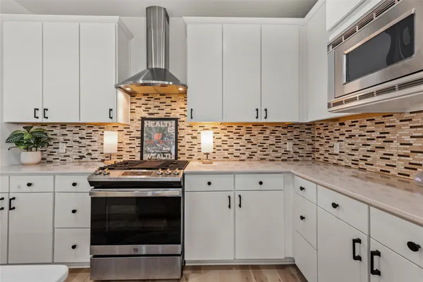a kitchen with a stove and white cabinets
