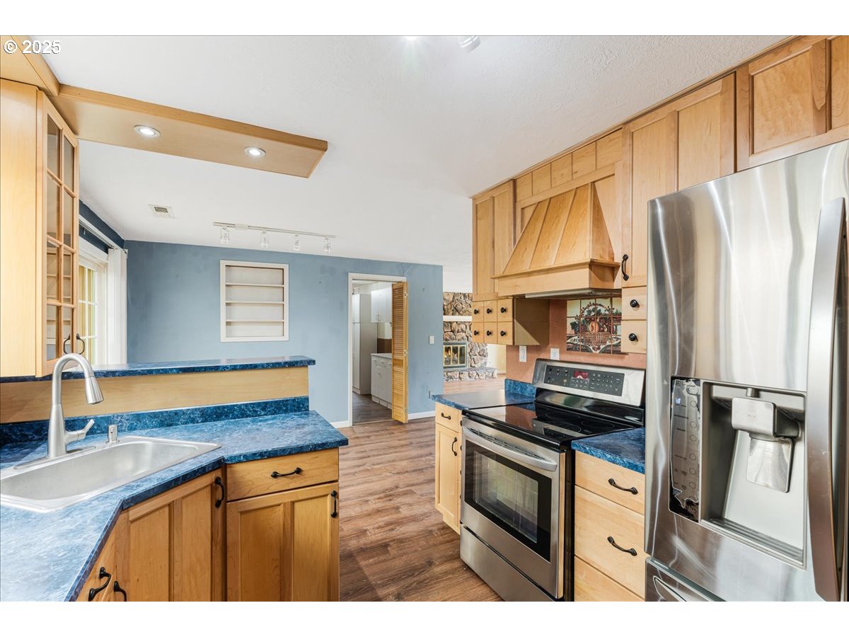 719 South Chehalem Street Newberg, OR 97132 - Photo 9 of 27 a kitchen with stainless steel appliances granite countertop a refrigerator stove oven and a sink