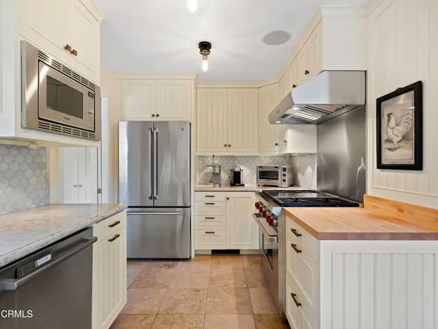 a kitchen with stainless steel appliances a stove microwave and a refrigerator