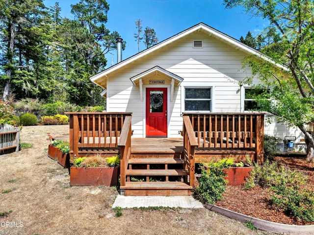 a view of a house with wooden deck front of house