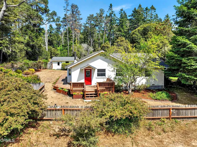 a view of house with backyard and sitting area