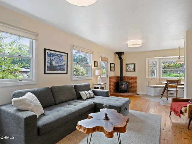 a living room with furniture wooden floor and a large window