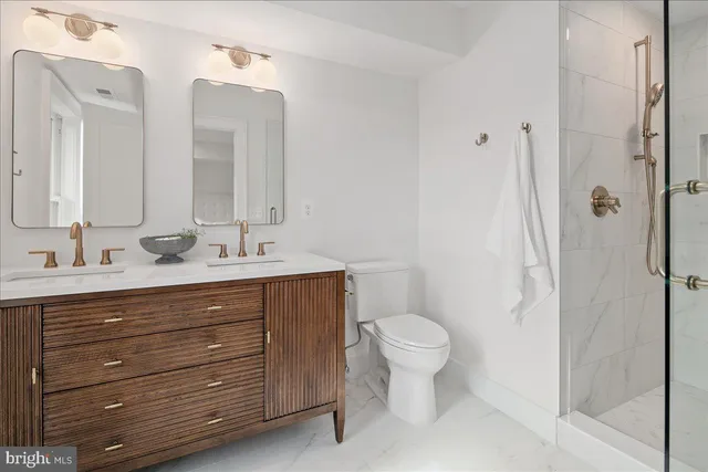 a bathroom with a granite countertop toilet sink and mirror