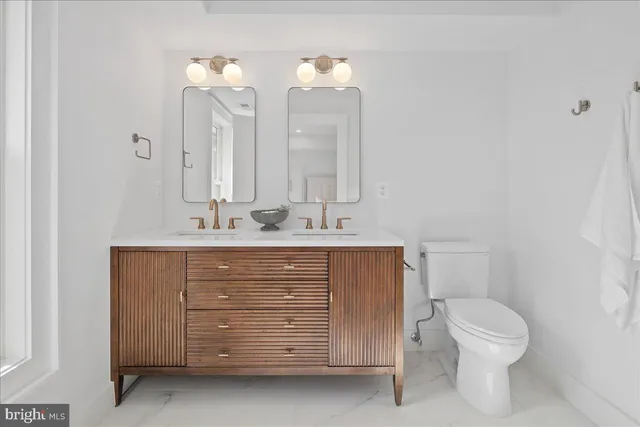 a bathroom with a sink a toilet and mirror
