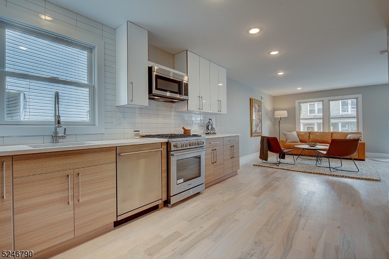 81 Mission Street, Unit 1 Montclair, NJ 07042 - Photo 1 of 19 a kitchen with stainless steel appliances granite countertop a stove a sink dishwasher and a microwave oven with white cabinets