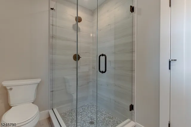 a white toilet next to a bathroom