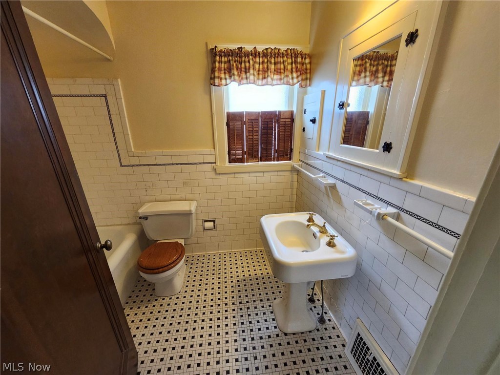 3819 Woodridge Road Cleveland Heights, OH 44121 - Photo 17 of 42 Bathroom with toilet, decorative backsplash, tile patterned flooring, and tile walls