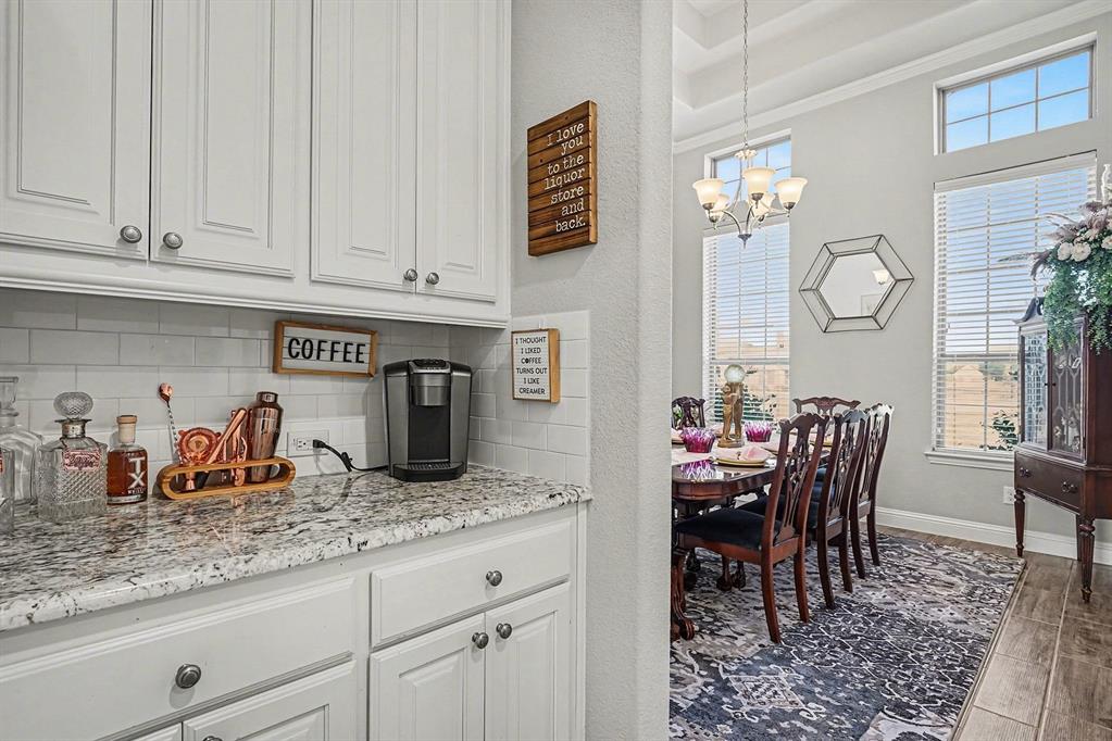 415 Silver Spur Trail Rockwall, TX 75032 - Photo 11 of 40 a kitchen with granite countertop white cabinets and stainless steel appliances