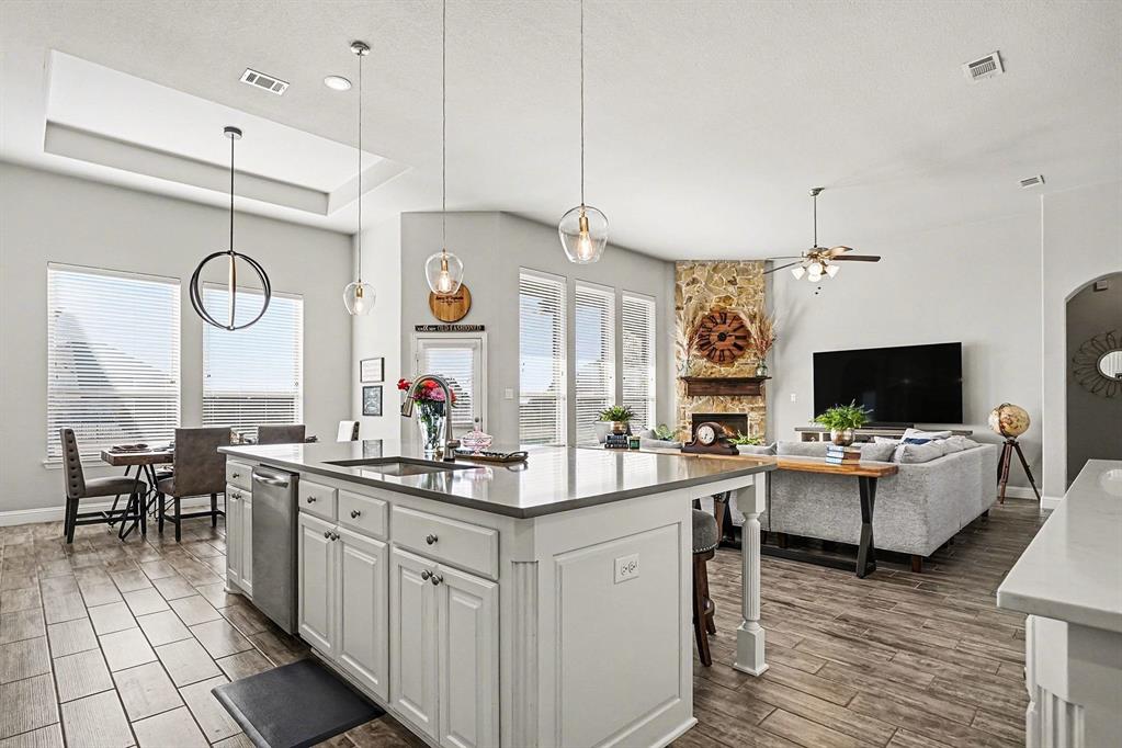 415 Silver Spur Trail Rockwall, TX 75032 - Photo 12 of 40 a kitchen with a sink and a stove top oven a wooden floor