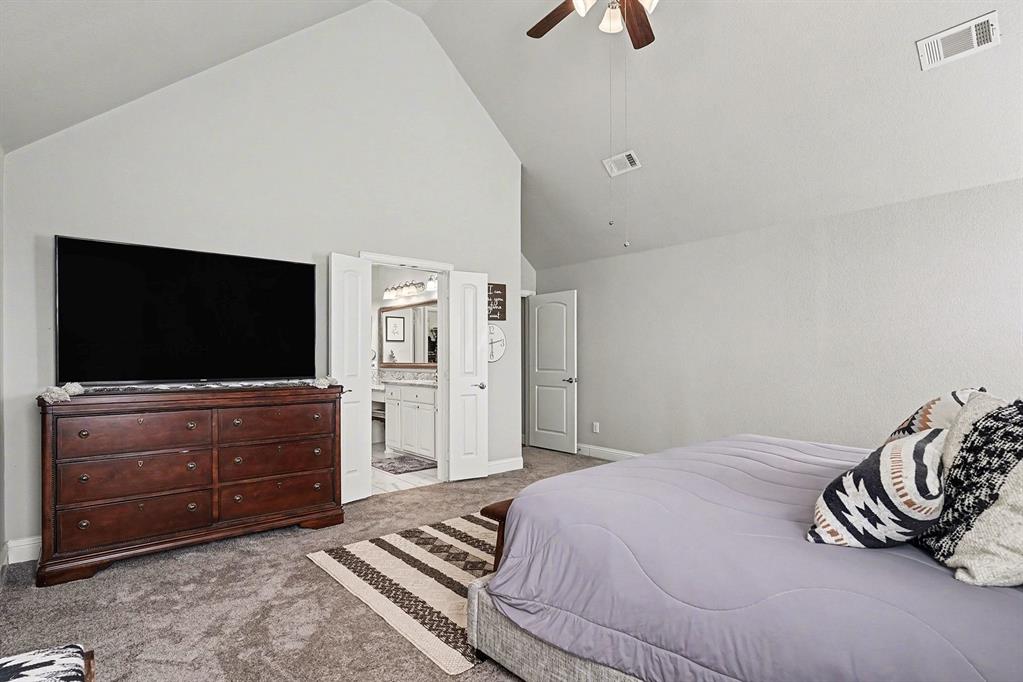 415 Silver Spur Trail Rockwall, TX 75032 - Photo 17 of 40 a bedroom with a bed and a television