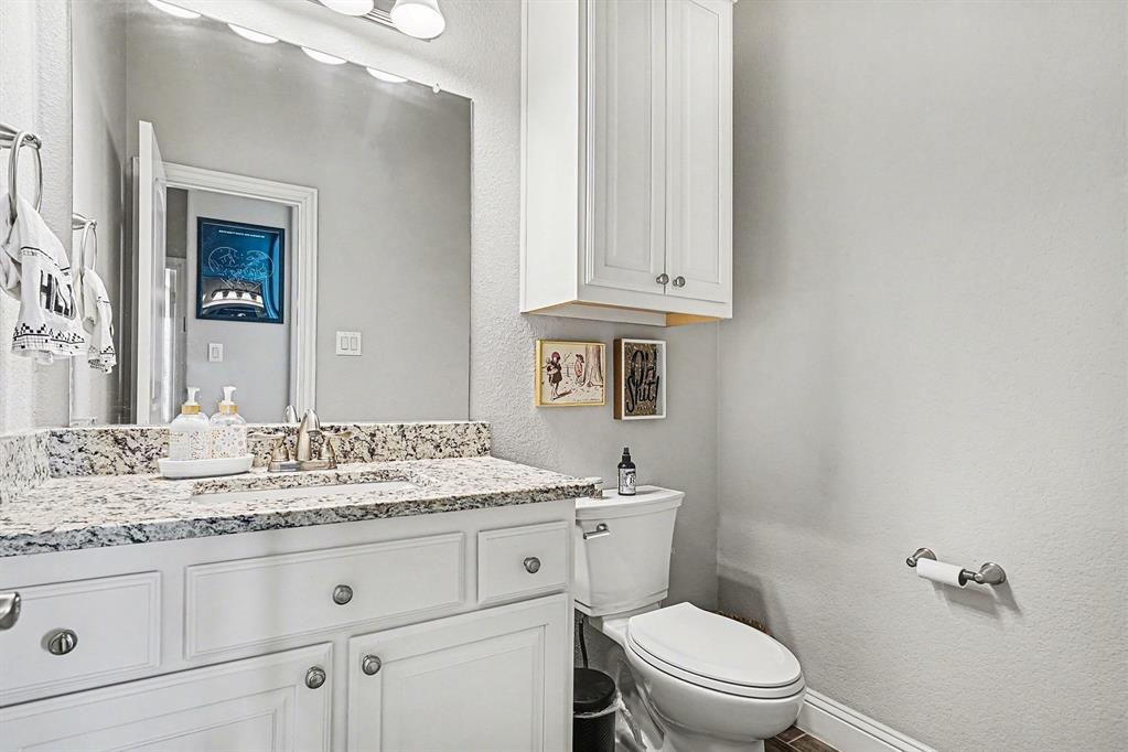 415 Silver Spur Trail Rockwall, TX 75032 - Photo 22 of 40 a bathroom with a granite countertop toilet sink and mirror