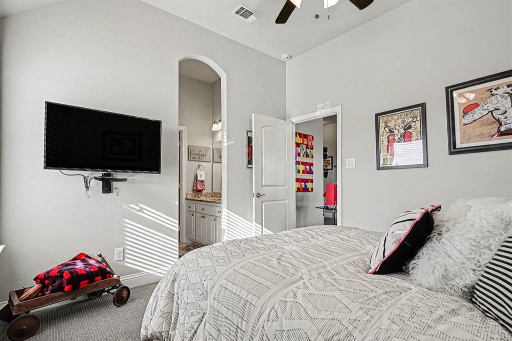 415 Silver Spur Trail Rockwall, TX 75032 - Photo 27 of 40 a bedroom with a bed and a flat screen tv