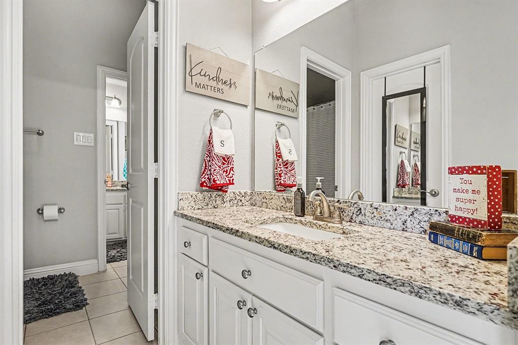 415 Silver Spur Trail Rockwall, TX 75032 - Photo 28 of 40 a bathroom with a granite countertop double vanity sink and a mirror