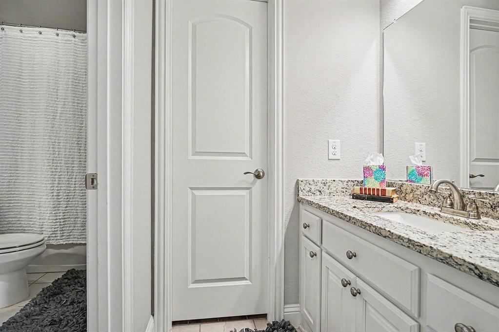 415 Silver Spur Trail Rockwall, TX 75032 - Photo 29 of 40 a bathroom with a granite countertop sink and a mirror
