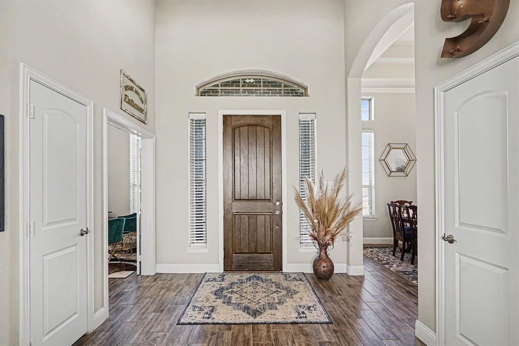 415 Silver Spur Trail Rockwall, TX 75032 - Photo 3 of 40 a view of a hallway with wooden floor and a livingroom