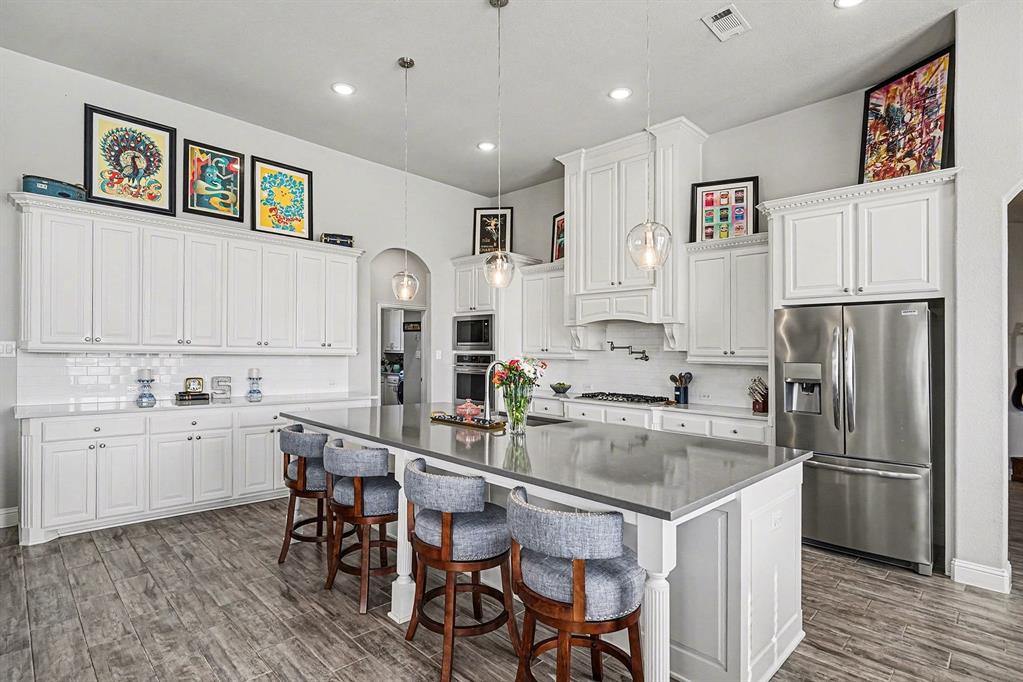 415 Silver Spur Trail Rockwall, TX 75032 - Photo 9 of 40 a kitchen with granite countertop a refrigerator and a stove top oven